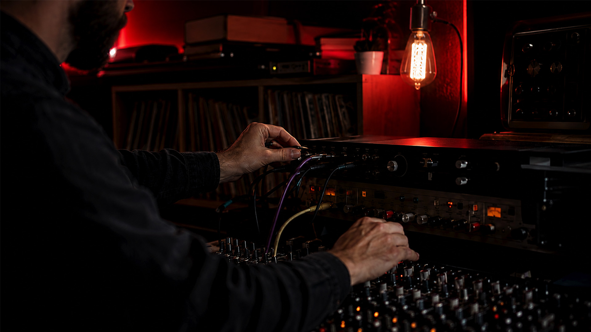 Hands adjusting studio audio interface knobs and cables