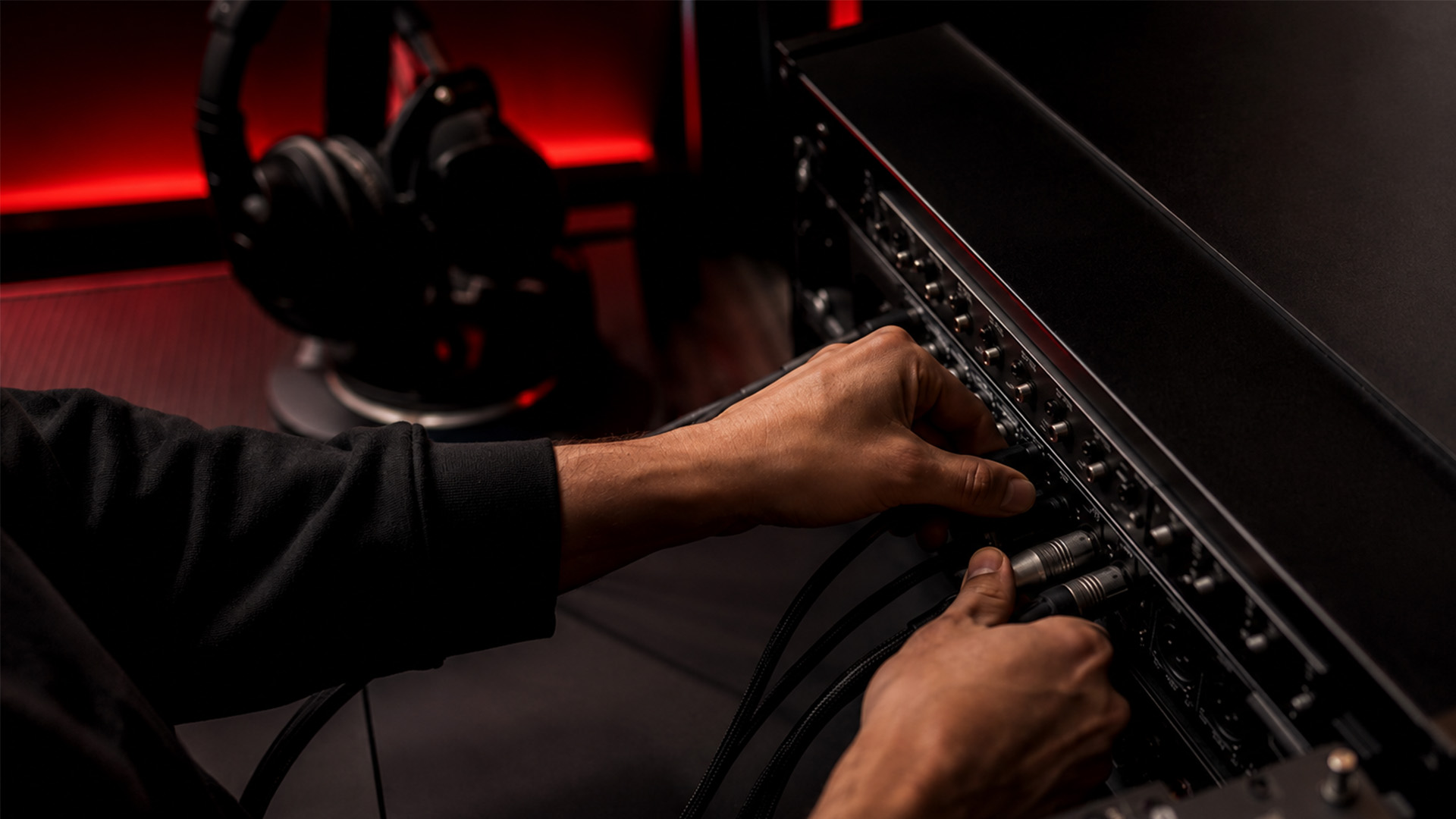Hands syncing audio cables in a studio