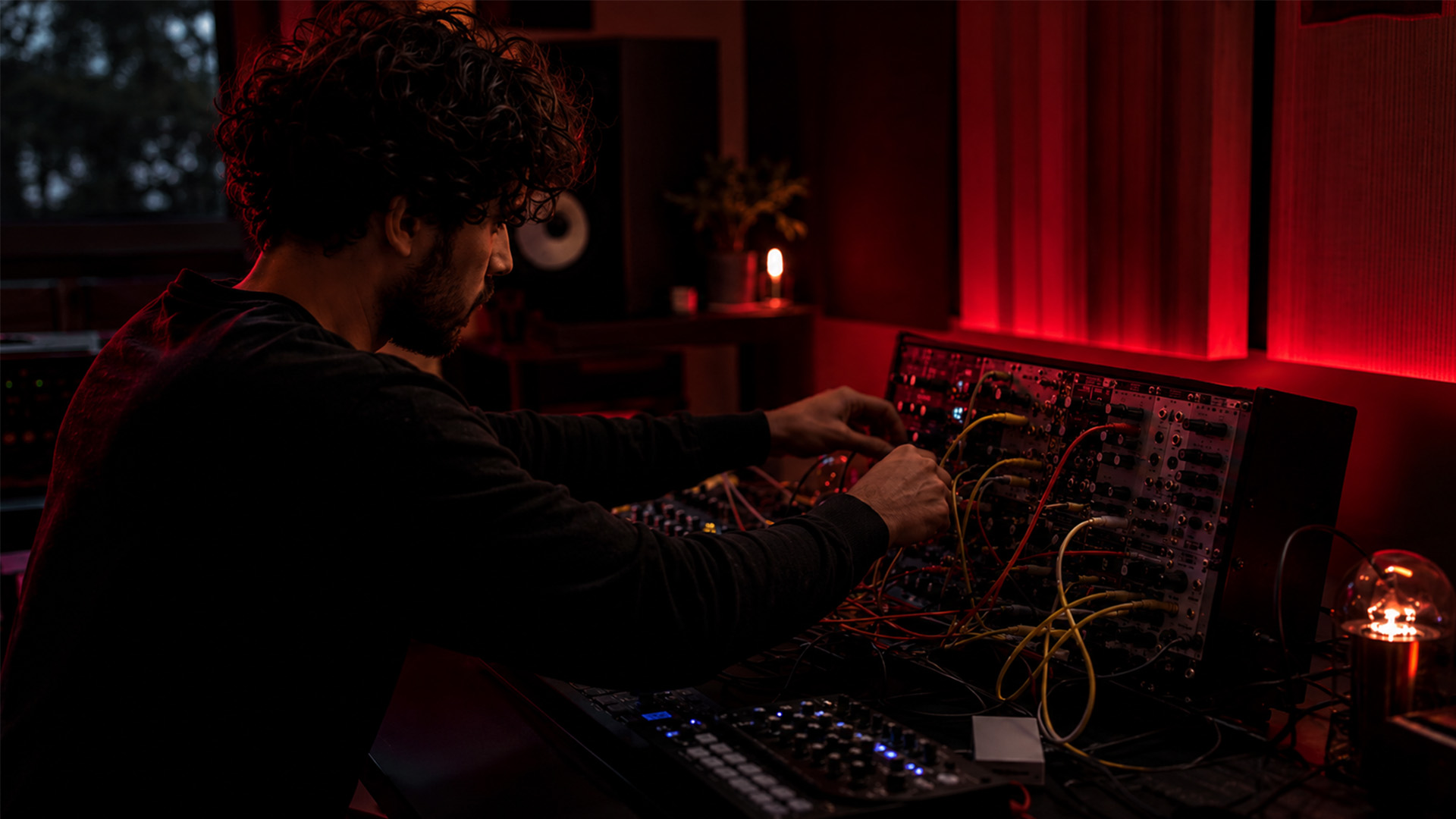 Hands patching a modular synth in a studio