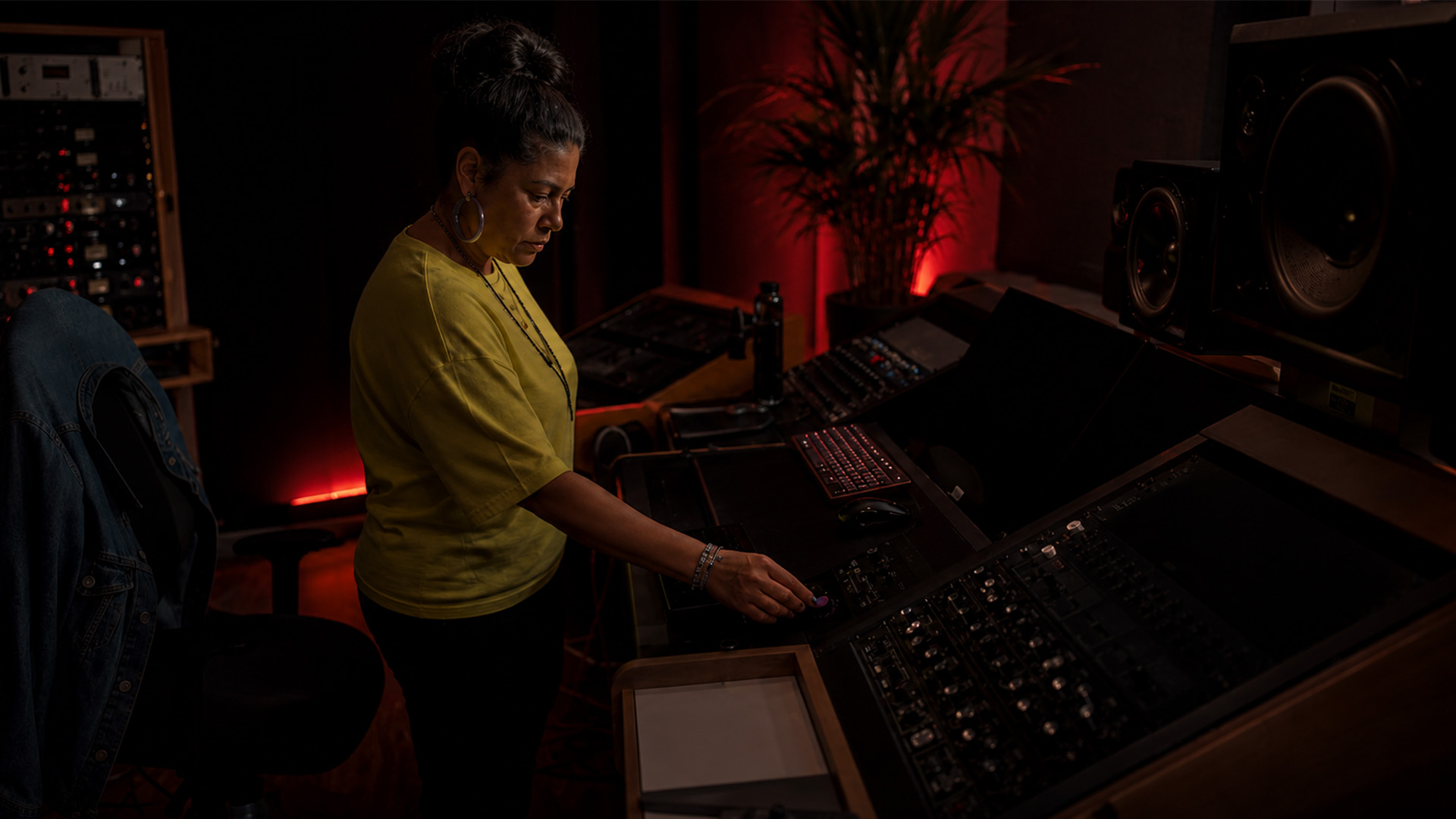 Hands adjusting a subtractive EQ on a mixing console