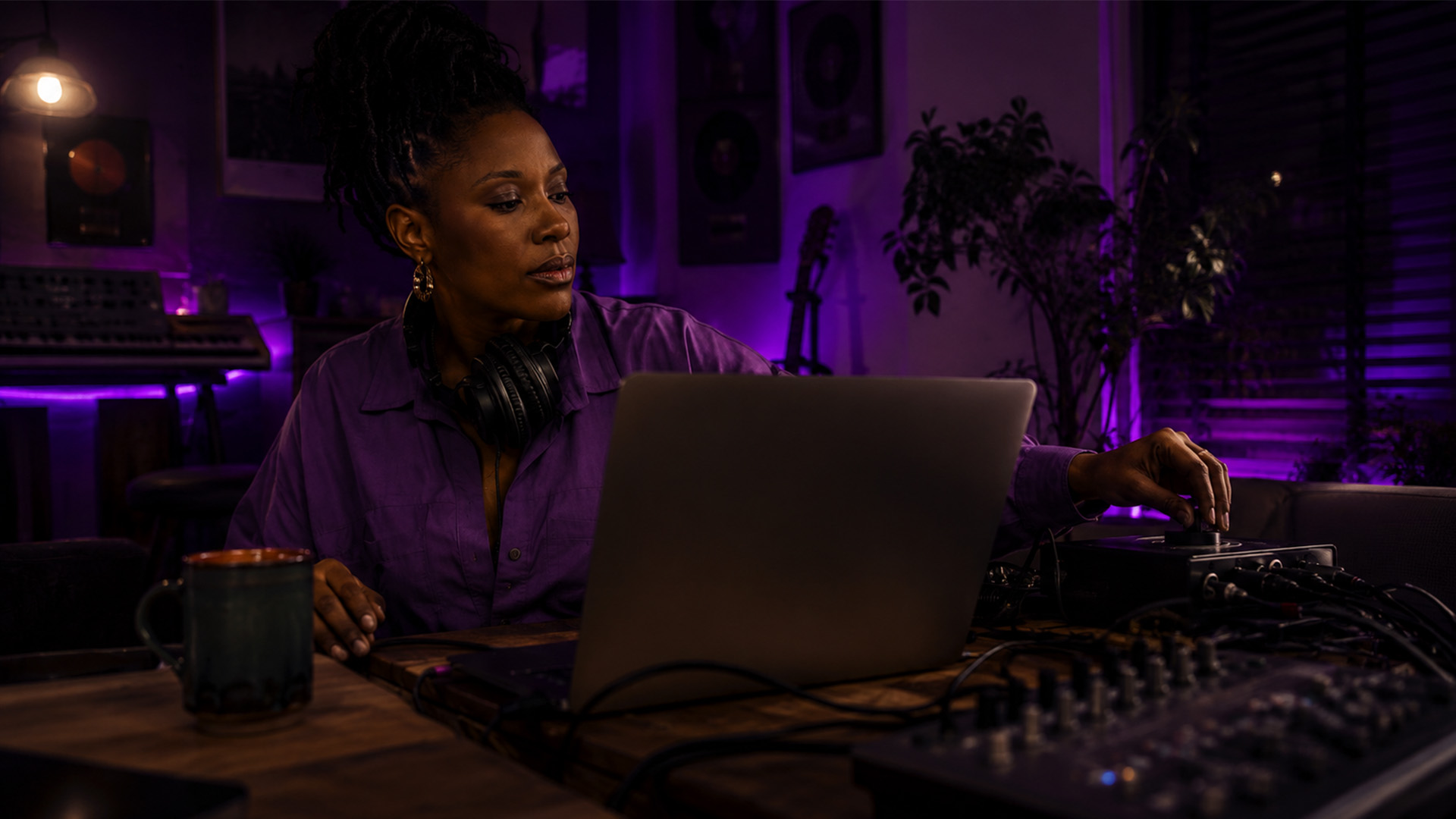 A woman adjusting an audio interface in a home studio