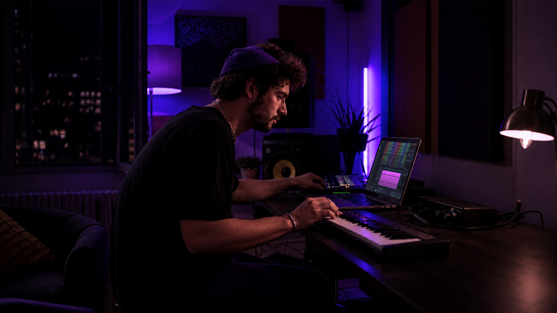 A producer adjusting DAW settings in a home studio