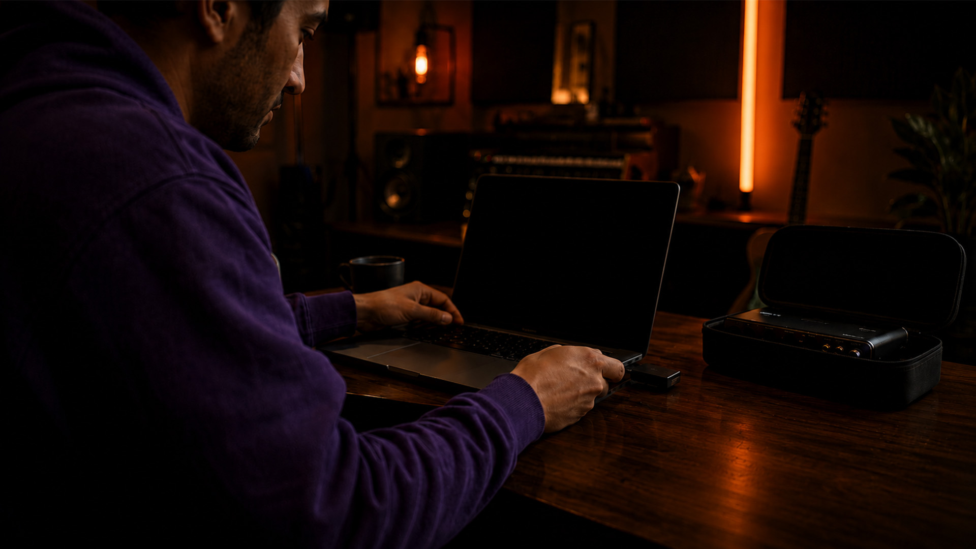 Hands connecting an external SSD to a laptop