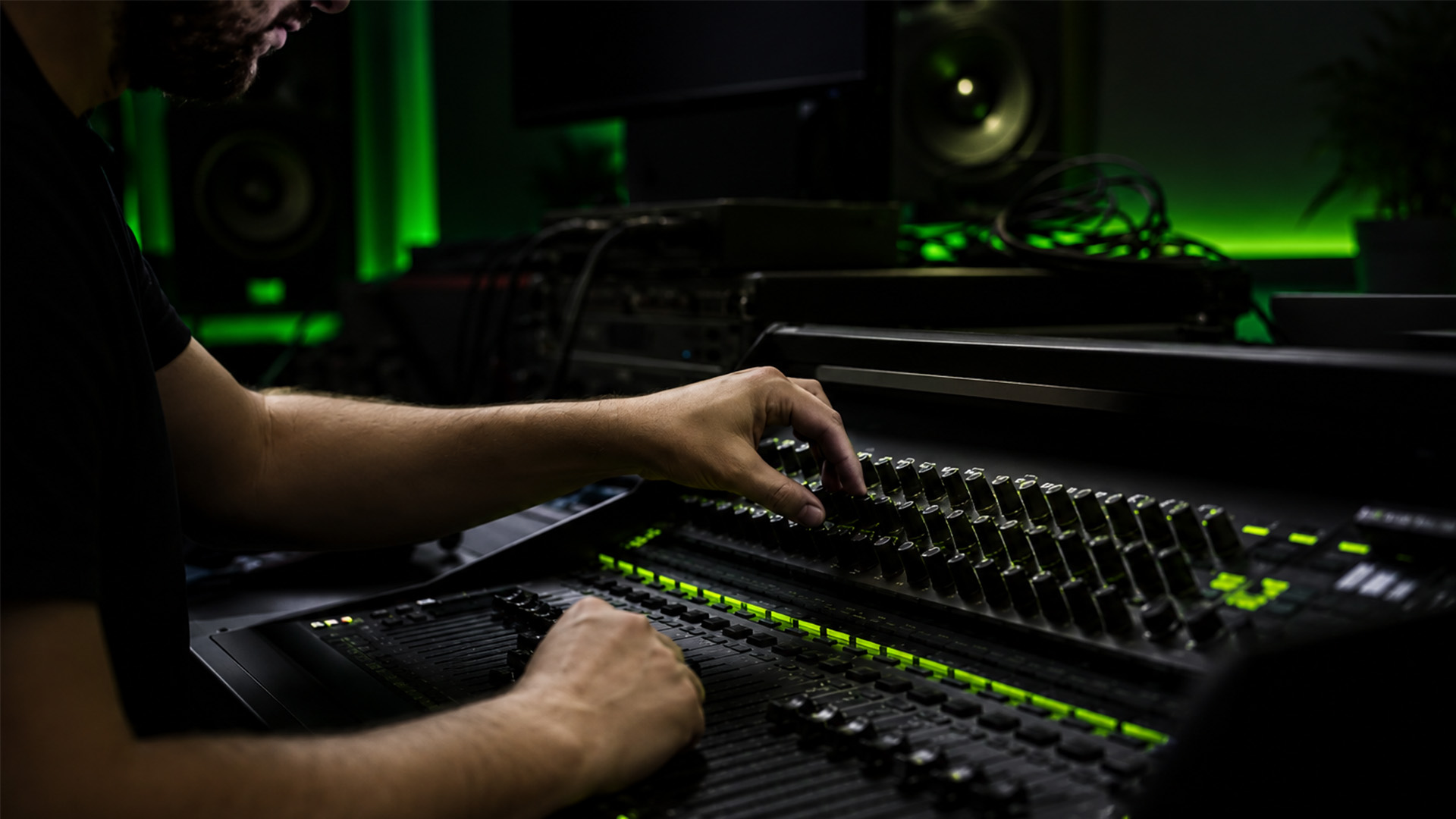 Hands adjusting mixer knobs in a music studio