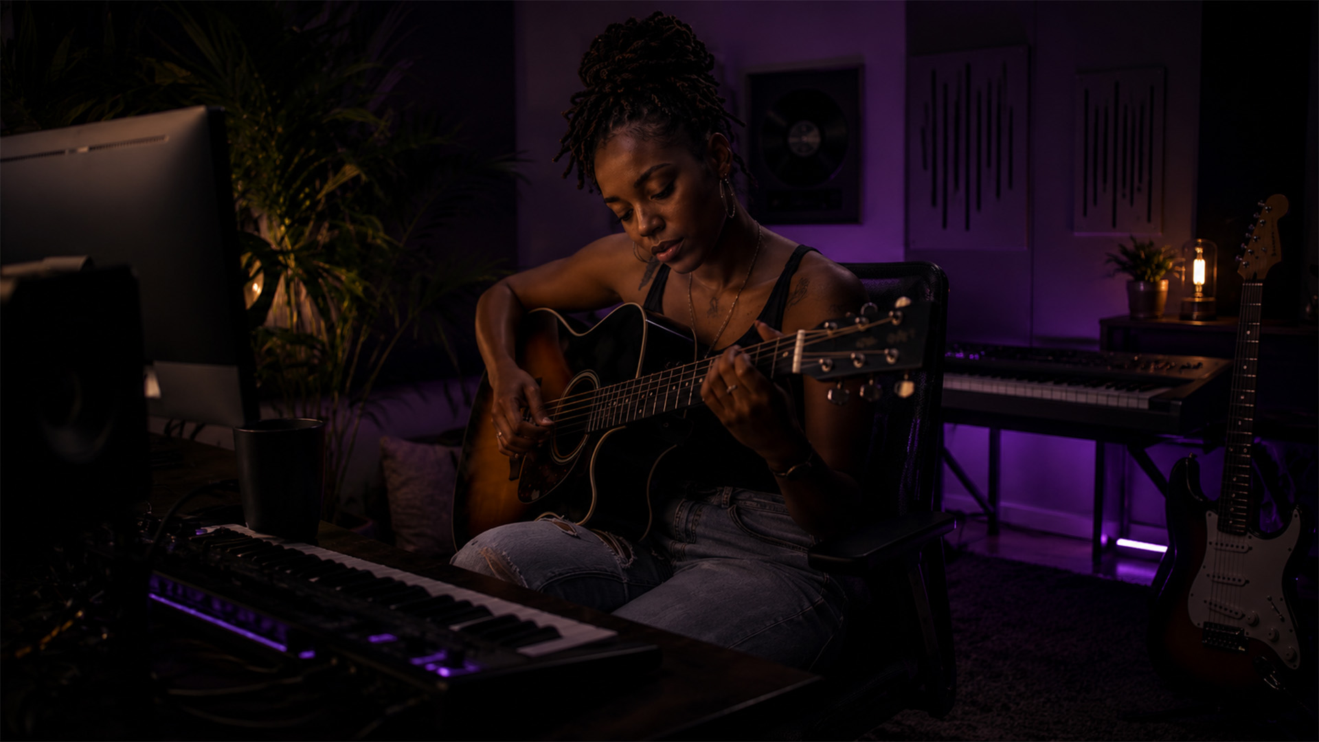 A songwriter composing in a cozy home studio with a guitar