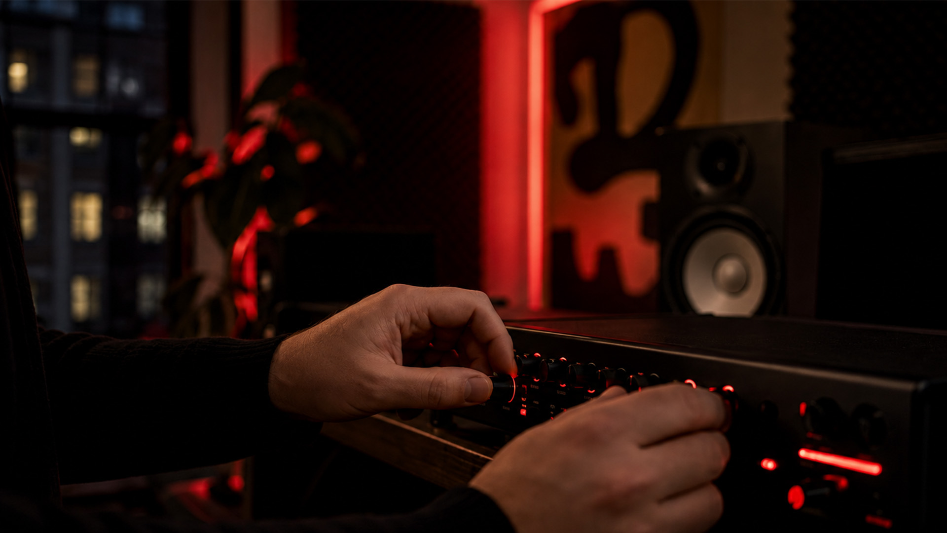 Hands adjusting audio interface knobs